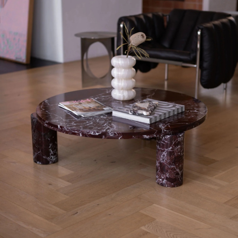 Burgundy Marble Round Coffee Table with cylindrical bases - styled with magazines & decor in modern living room