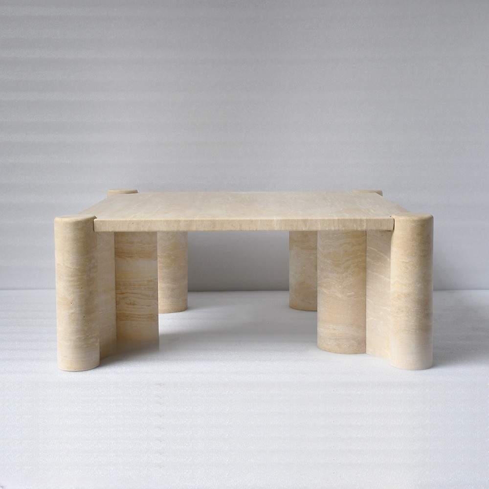 Square travertine coffee table in modern living room - styled with dark blue velvet sofa