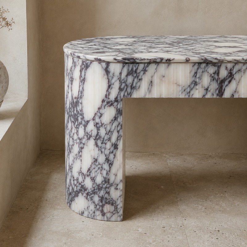 Close-up detail of Calacatta Viola marble fluted edge, bold dark purple-black veining on creamy white stone